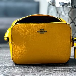 Mustard yellow Coach crossbody bag.